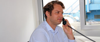 Mitarbeiter im blauen Hemd am Telefon Mitarbeiter im blauen Hemd am Telefon